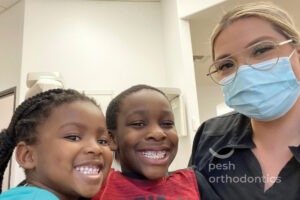 Two happy kids with a Pesh Orthodontics team member, showing off their beautiful smiles after expert orthodontic treatment in Murrieta and Menifee.