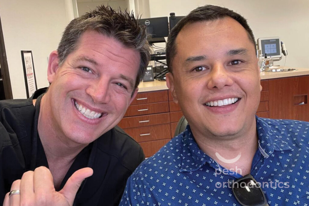 Dr. Pesh with a smiling orthodontic patient after treatment