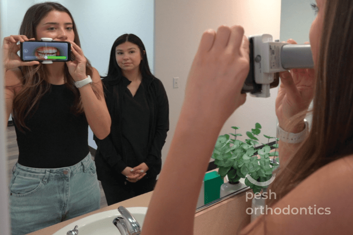 Teen taking smile photos with a smartphone during an express orthodontic consultation at Pesh Orthodontics