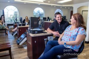 Adult patient consulting with an orthodontist about braces at Pesh Orthodontics in Murrieta