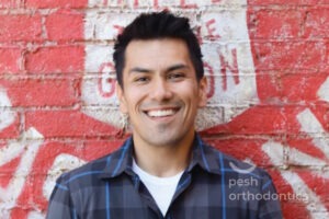 Smiling adult orthodontic patient showing straight teeth after braces treatment at Pesh Orthodontics in Murrieta CA