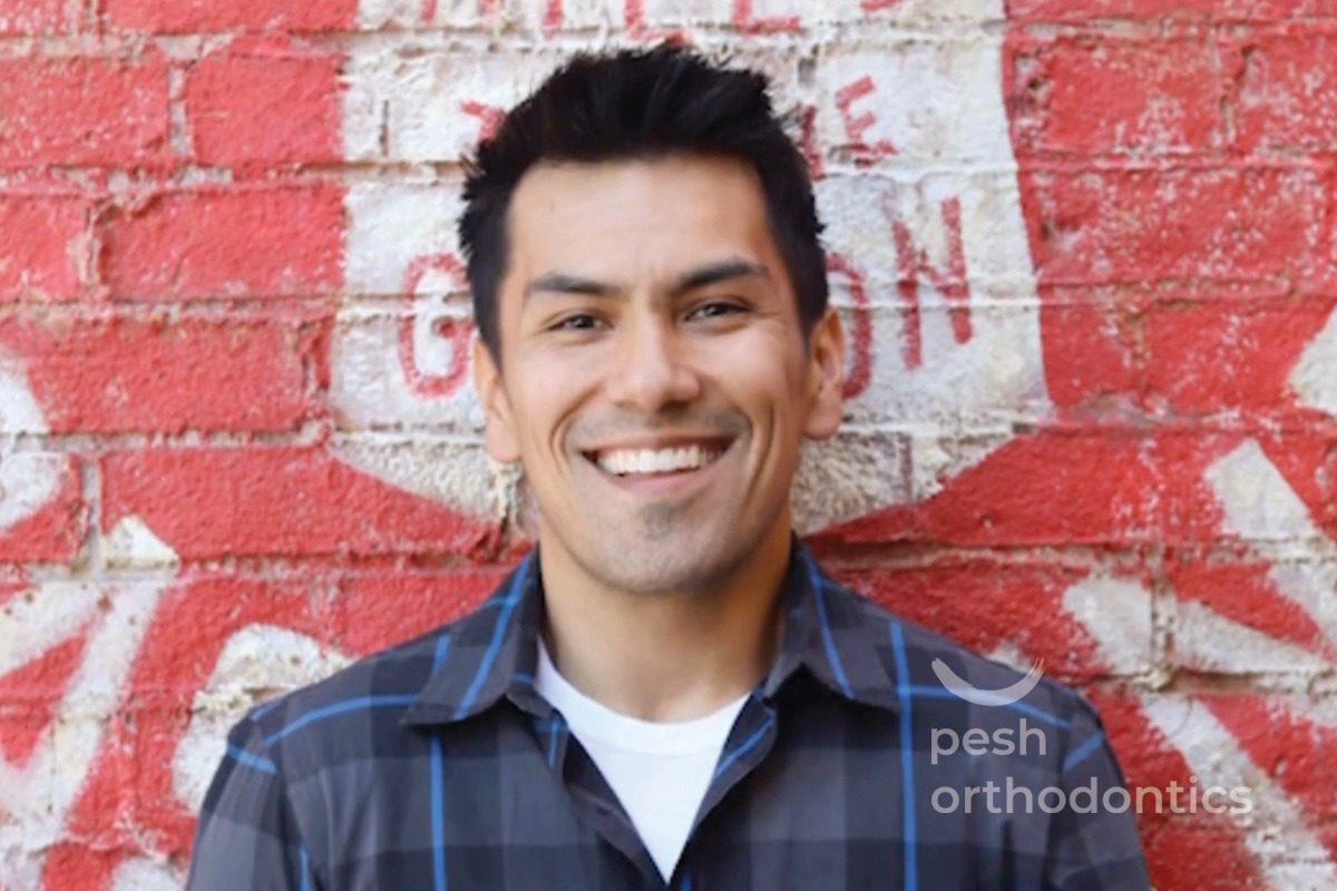 Smiling adult orthodontic patient showing straight teeth after braces treatment at Pesh Orthodontics in Murrieta CA